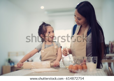 mother and daugthter cooking togather for make bread for dinner, in kitchen room, kid, children