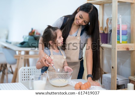 mother and daugthter cooking togather for make bread for dinner, in kitchen room, kid, children