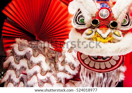 Chinese lion dance for Chinese new year with red fan in the background