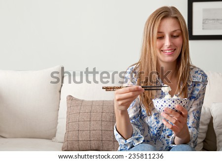 https://thumb1.shutterstock.com/display_pic_with_logo/840583/235811236/stock-photo-portrait-of-attractive-young-woman-having-a-night-in-at-home-enjoying-eating-japanese-white-rice-235811236.jpg