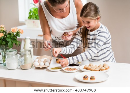 Woman Decorating Cupcakes pregnant mum her little daughter baking stock photo 483749908 Woman Decorating Cupcakes pregnant mum her little daughter baking stock photo 483749908