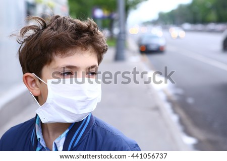 preteen boy in protection mask on the highway city background