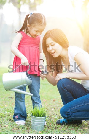 Asian mother and daughter are exploring nature and having fun. Family outdoor fun, morning with sun flare.