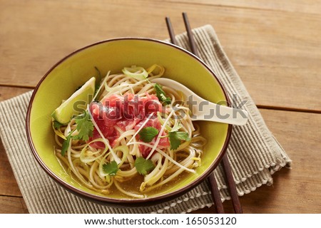 Beef meat rice noodle pho soup on wooden table