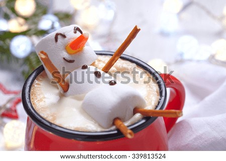 Red mug with hot chocolate with melted marshmallow snowman