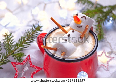 Red mug with hot chocolate with melted marshmallow snowman