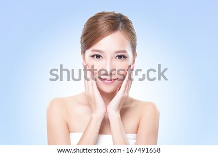 Beautiful face of young adult woman with clean fresh skin - isolated blue background, asian