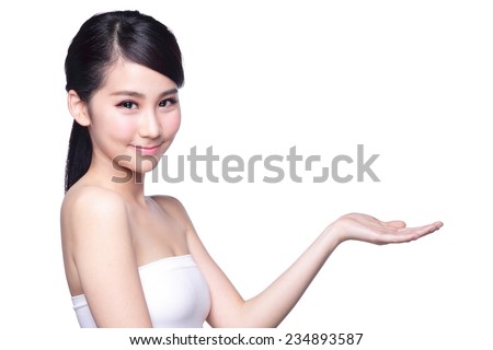Beautiful young woman with healthy clean skin presenting something on her hand. Isolated on white. asian beauty