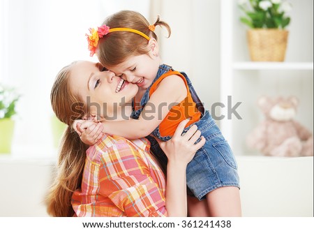 happy family mother and child girl daughter playing laughing and hugging at home