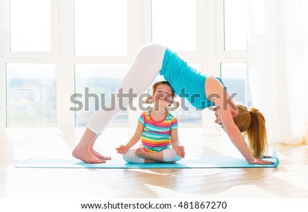 family mother and child daughter are engaged in fitness, yoga, exercise at home