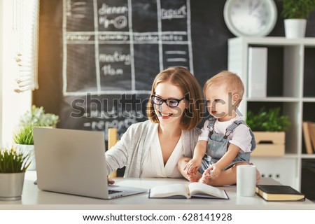 Businesswoman mother  woman with a toddler working at the computer 