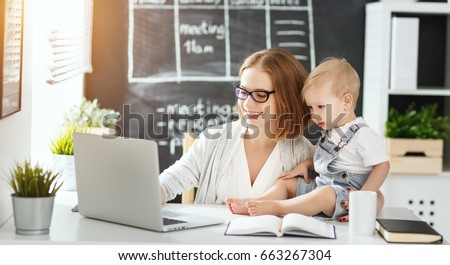 Businesswoman mother woman with a toddler working at the computer