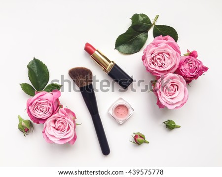 Decorative flat lay composition with cosmetics and flowers. Flat lay, top view on white background