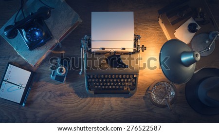 Retro journalist's desk 1950s style with vintage typewriter, phone and lamp at night time, top view