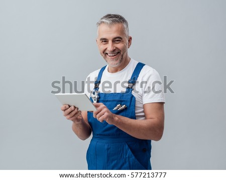 Confident plumber or mechanic connecting with a digital tablet and using apps