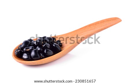 Black beans in wooden spoon isolated on white background