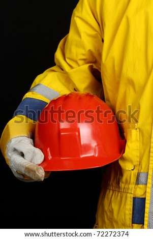 man holding red helmet over black background