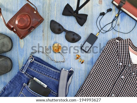 Set of men's clothing and accessories on blue wooden table. Hipster concept