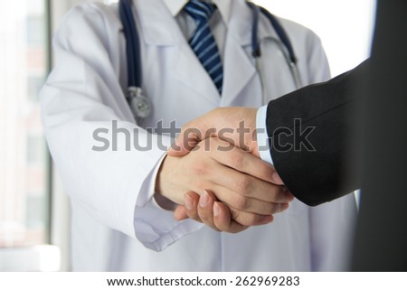 Doctor and businessman shaking hands