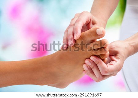 Cực cận của vật lý trị liệu làm massage bấm huyệt vào bóng đá nữ. nền đầy màu sắc.