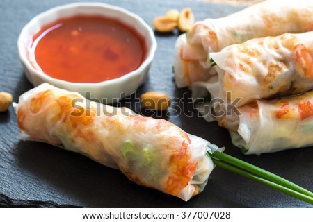 Macro close up of chicken and prawn Vietnamese rice rolls served with bittersweet sauce.