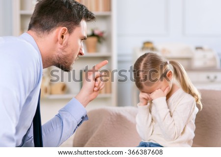 Strict father punishing his daughter