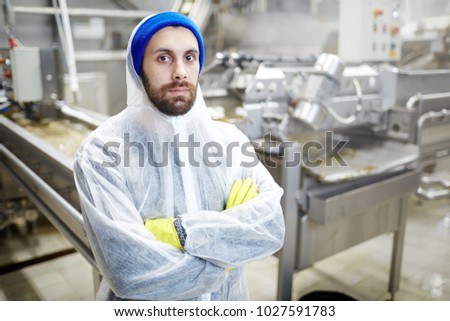 Fish factory staff in uniform crossing his arms on chest and looking at camera