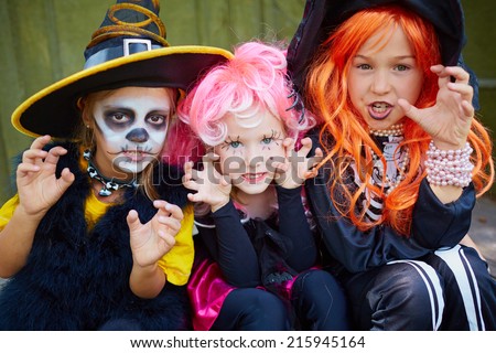portrait of three little girls in halloween costumes looking at camera with frightening gesture - Halloween Costumes Three Girls portrait of three little girls in halloween costumes looking at camera with frightening gesture - Halloween Costumes Three Girls