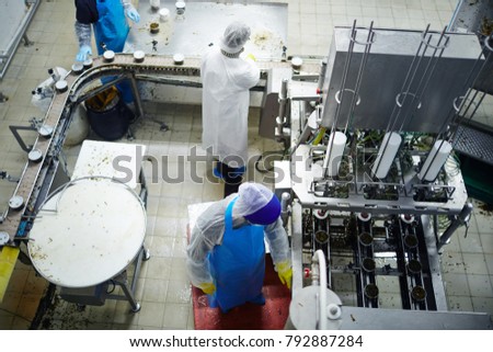 Overview of producing-line in seafood production plant with staff in uniform working there