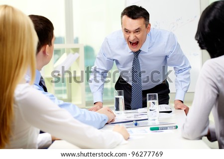 Angry businessman shouting at his workers with an expressive look