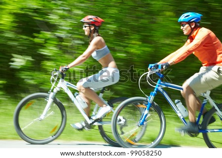 Image in motion of two bicyclists riding on country road
