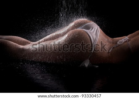 Sexy woman butts under shower, black background