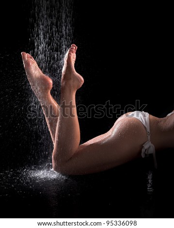 Sexy woman legs and butts under shower, black background
