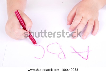 Preschool age child writing alphabet, close up of hands and paper