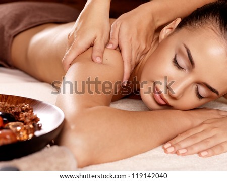 Masseur doing massage on woman body in the spa salon. Beauty treatment concept.