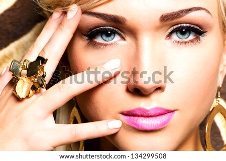 Closeup portrait of beautiful face of sexy woman with fashion makeup and gold ring on finger