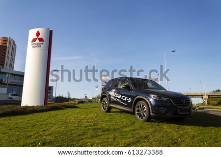 PRAGUE, CZECH REPUBLIC - MARCH 31: Mitsubishi motors company logo with Mazda car in front of dealership building on March 31, 2017 in Prague, Czech republic.