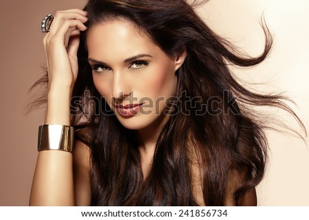 Beautiful woman with long dark hair posing on beige background. - stock ...