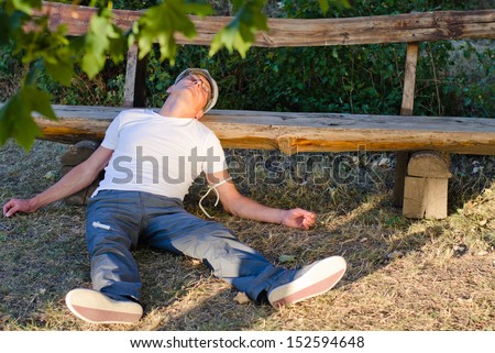 stock-photo-caucasian-middle-aged-man-lying-down-on-the-ground-leaning-his-head-on-a-bench-feeling-sick-152594648.jpg