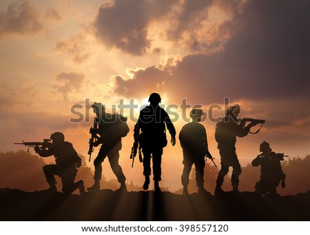 Six military silhouettes on sunset sky background