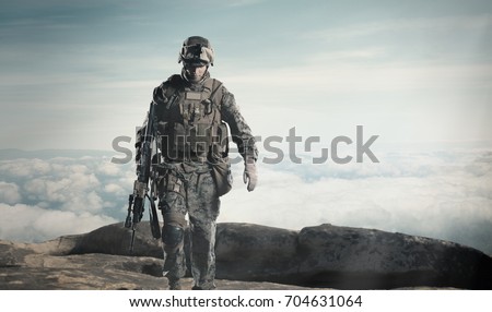 soldier with a rifle. Steps against clouds.
