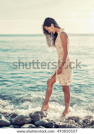 https://thumb1.shutterstock.com/display_pic_with_logo/948934/493850107/stock-photo-beautiful-young-woman-walking-on-pebble-beach-near-the-sea-toned-image-493850107.jpg
