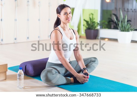 Fit woman doing stretching pilates exercises in fitness studio