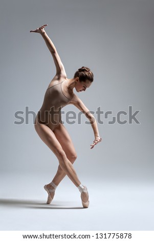 young beautiful dancer posing on a studio background