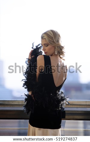 https://thumb1.shutterstock.com/display_pic_with_logo/966950/519274837/stock-photo-portrait-of-beautiful-blonde-woman-wearing-a-black-and-champagne-color-evening-dress-with-a-feather-519274837.jpg