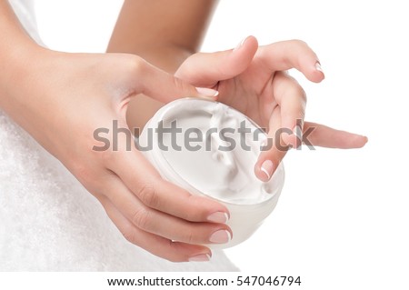 Woman applying body cream. Close-up composition of hands with white jar isolated on white background. Horizontal composition.