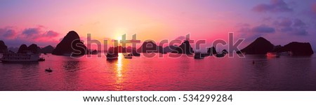 Beautiful purple sunset and rock islands in Halong Bay Vietnam Southeast Asia. Panorama. Junk boat cruise to Ha Long Bay. Exotic scenery. Panoramic view. Landscape Pink sky. Famous landmark of Vietnam