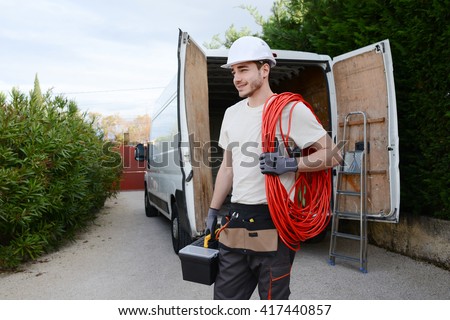 handsome young construction worker with his commercial van on background