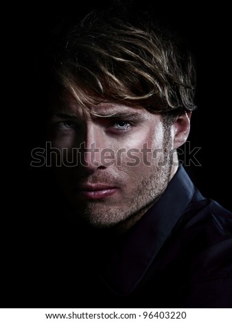 Man - male beauty portrait on black background. Young Caucasian man staring serious close up.
