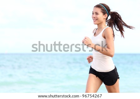 Running woman. Female runner jogging during outdoor workout on beach. Beautiful fit mixed race Fitness model outdoors.